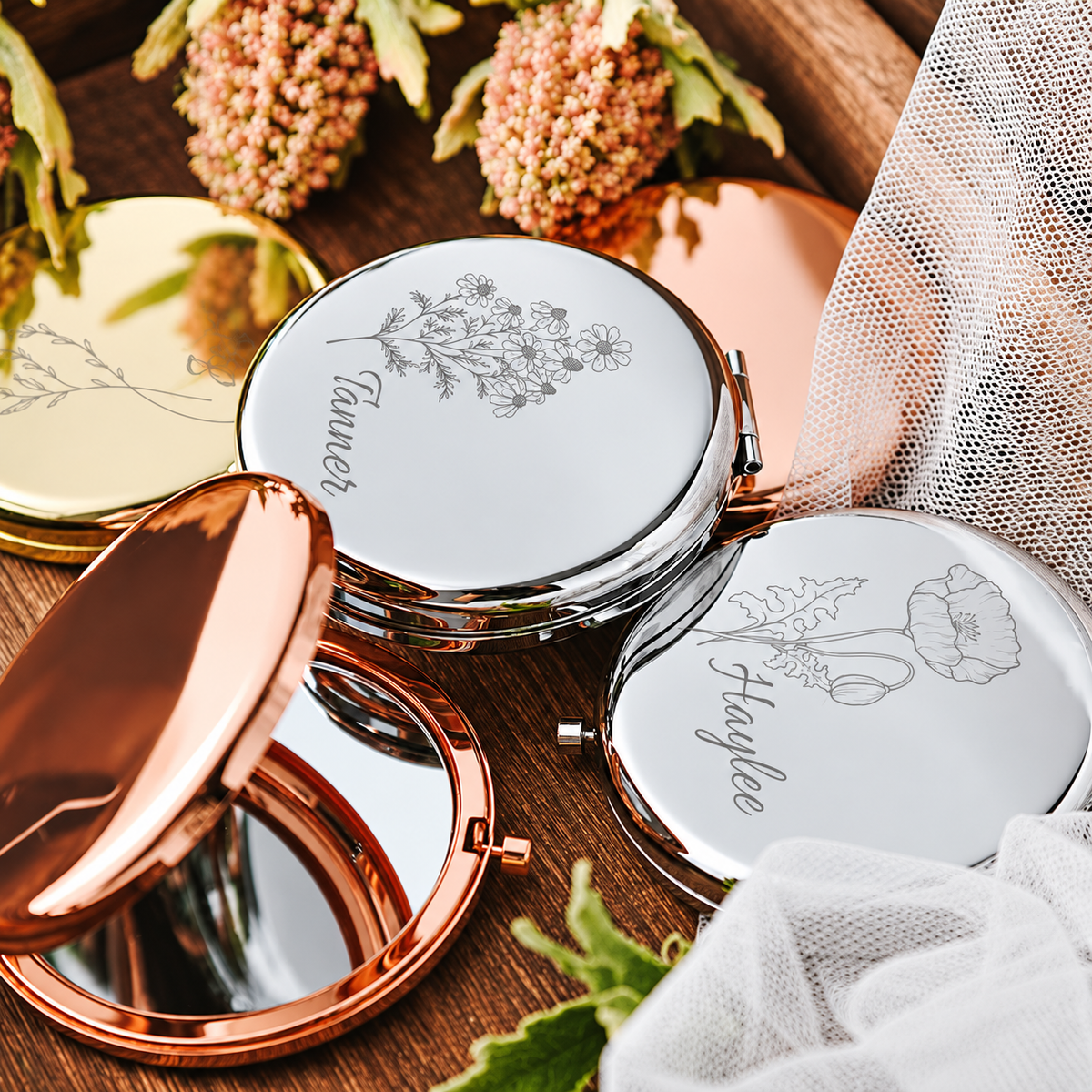 Personalized floral compact mirrors shown in gold-tone, silver-tone and rose gold-tone finishes with one mirror open