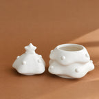 Tree-shaped pet urn with the star-topped lid removed to show the wide storage opening