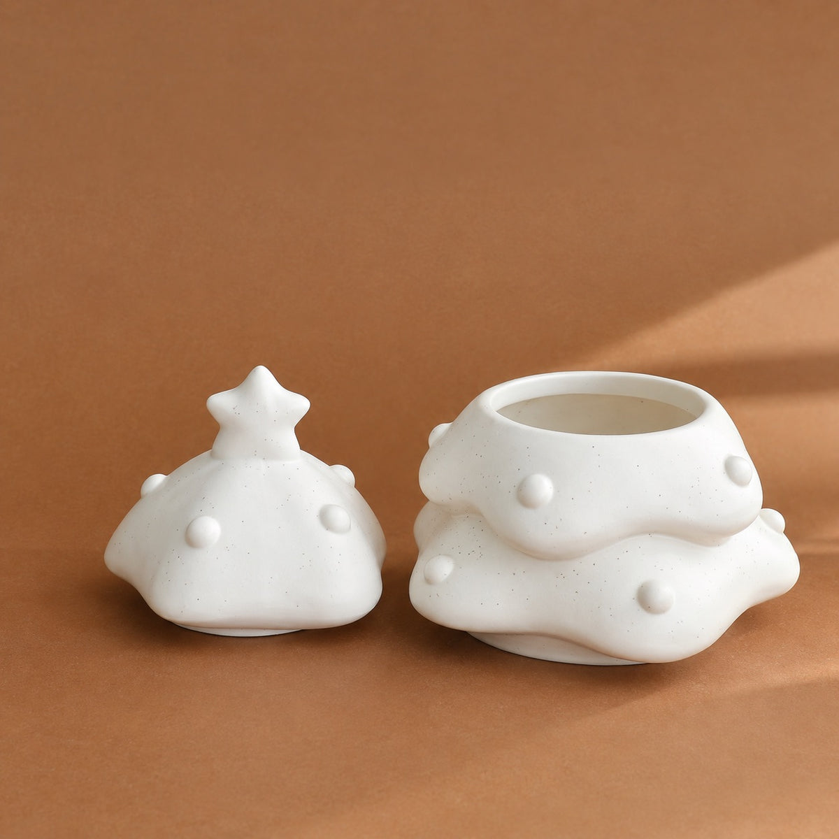 Tree-shaped pet urn with the star-topped lid removed to show the wide storage opening