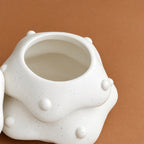 Close-up of the wide interior opening and white speckled finish on the tree-shaped pet urn 