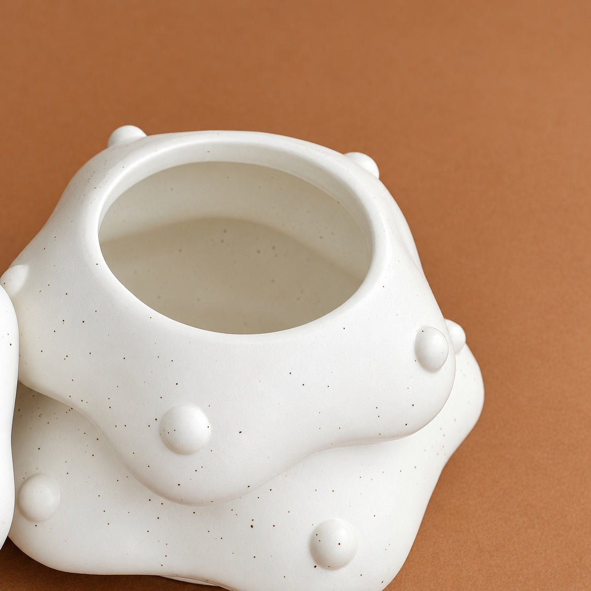 Close-up of the wide interior opening and white speckled finish on the tree-shaped pet urn 