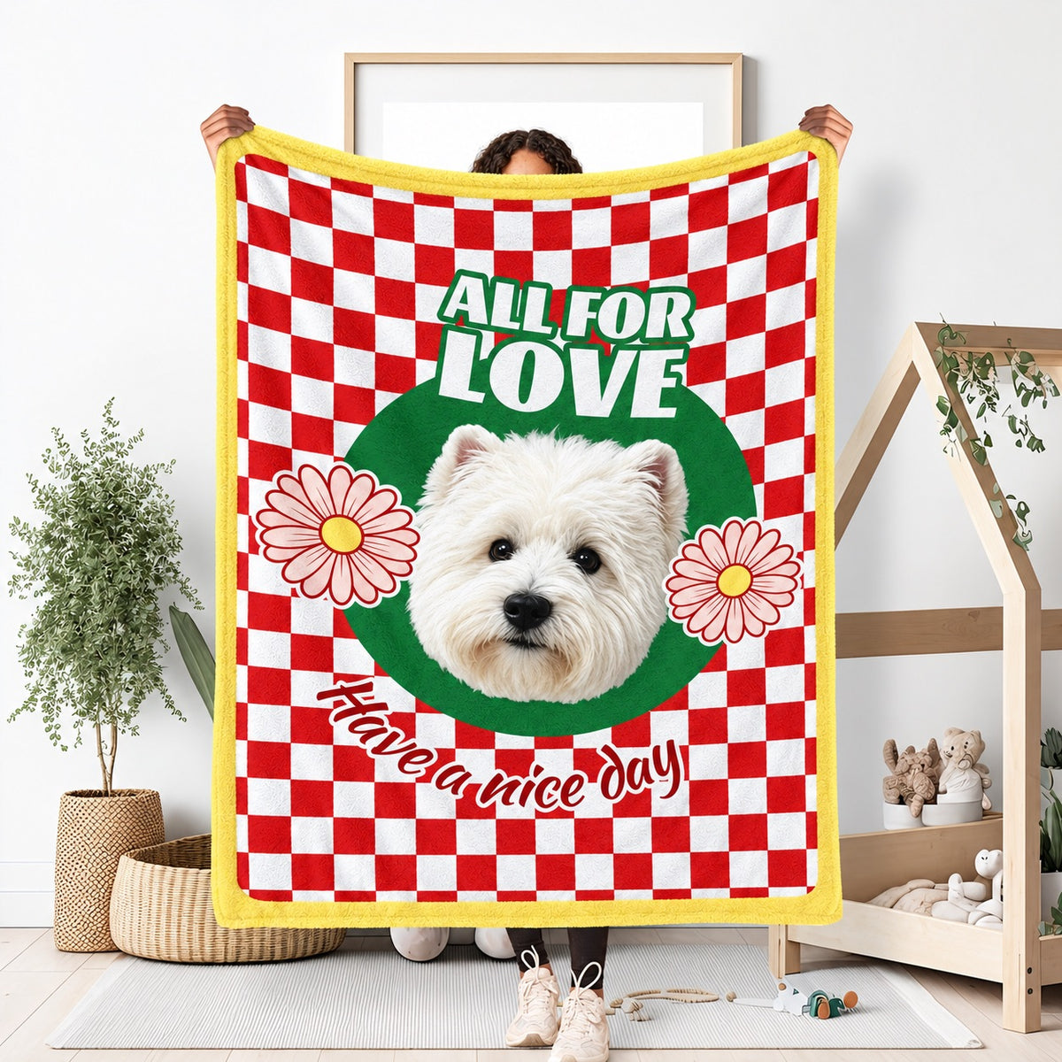 Person holding a red checkerboard white-dog portrait blanket with flowers and the words All for Love