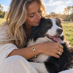Woman hugging her dog while wearing a gold custom portrait memorial bracelet |