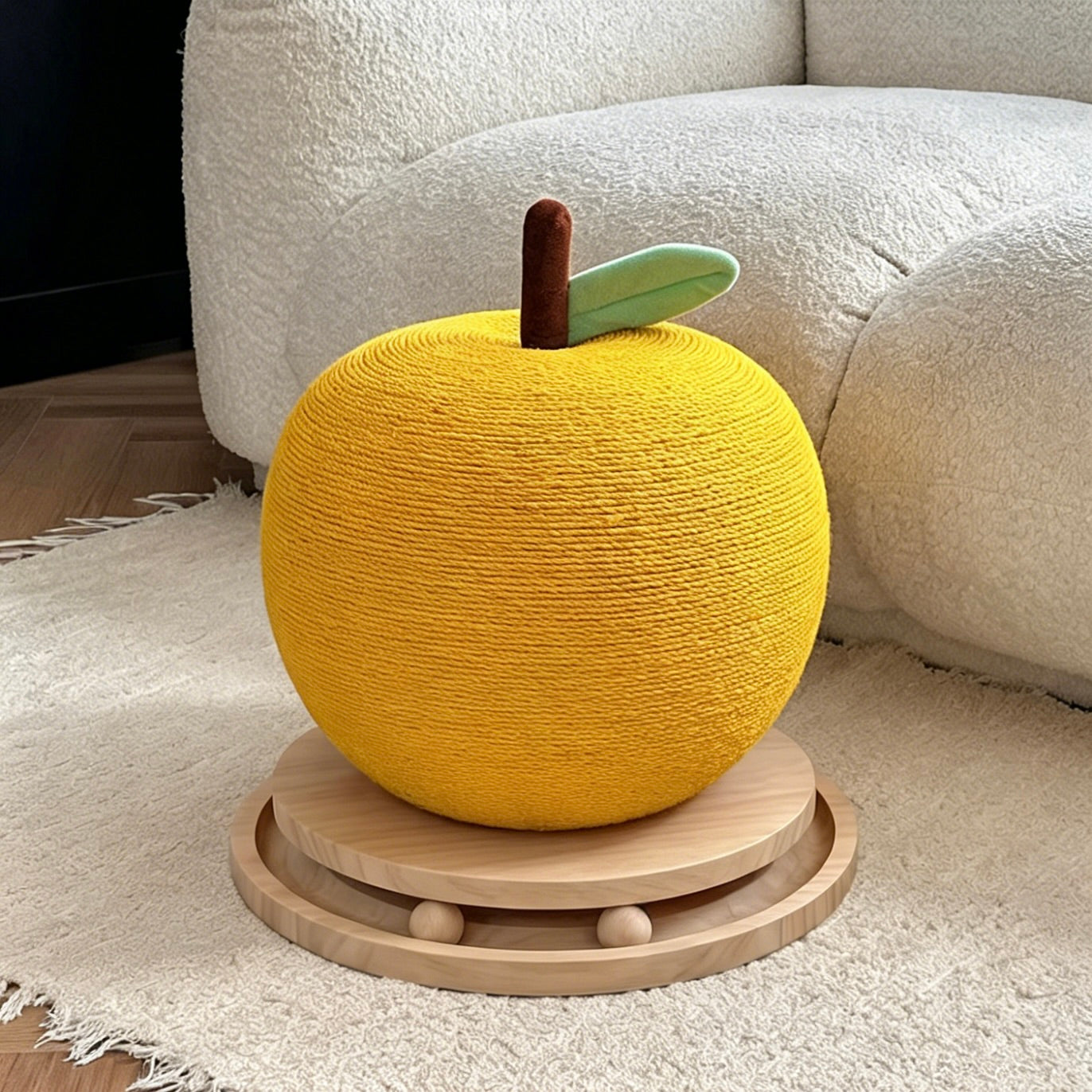 Yellow apple cat scratcher beside a white sofa