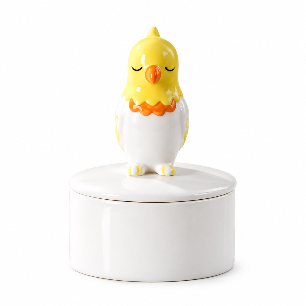 Ceramic bird memorial urn with a yellow, white and orange bird figure with closed eyes on the lid